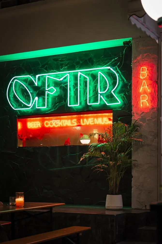 ป้ายนีออน OFTR Bar เรืองแสงเหนือทางเข้าบาร์