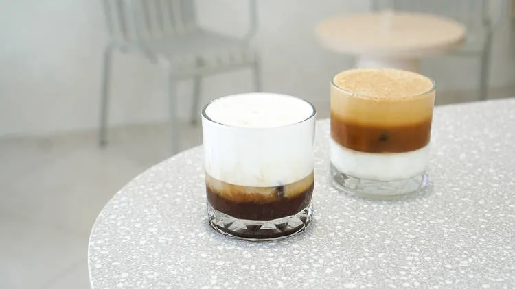 กาแฟเลเยอร์สองแก้วบนโต๊ะหินขัดที่ PAGA Microroastery