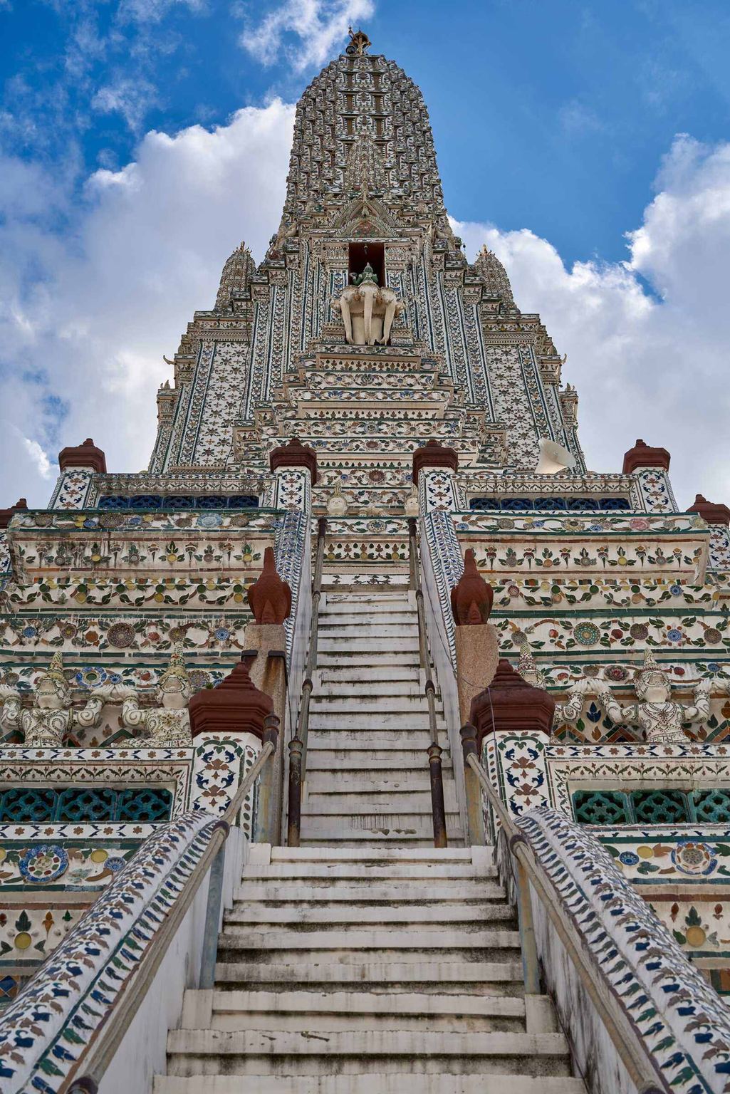 The porcelain-tiled prang of Wat Arun rising against a bright sky