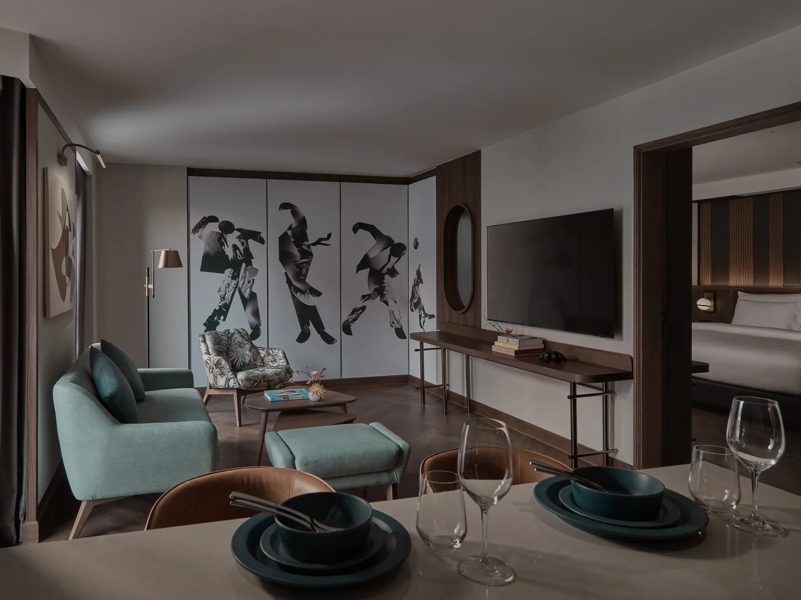 The living room of a suite at Public House Bangkok, with a pale sofa, a low table and a window onto the city