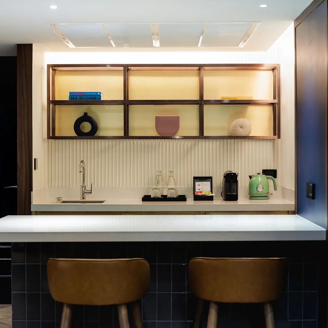 The kitchenette counter and stools in a suite at Public House Bangkok
